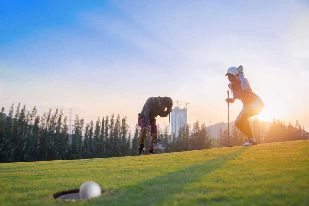 Woman golfer putting on the green